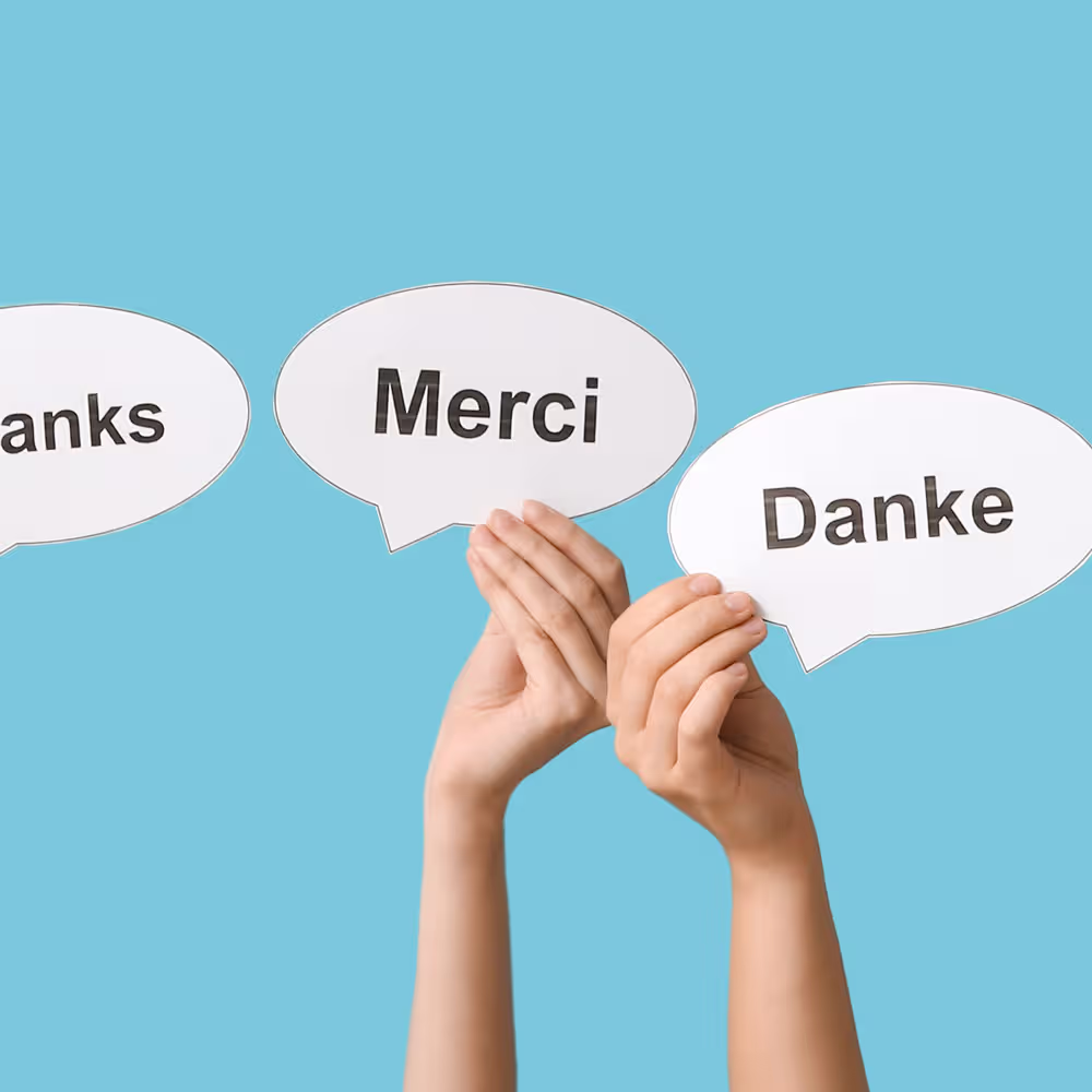 Foto zwei h&auml;nde die Dankesprachblasen in verschiedenen Sprachen hochhalten