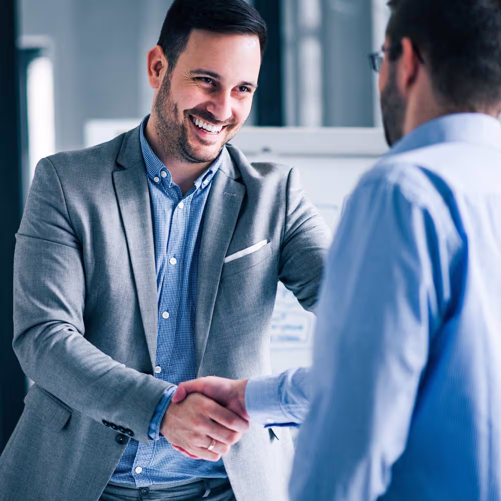 Foto zwei Mitarbeiter Kollegen die sich die H&auml;nde reichen zum gratulieren