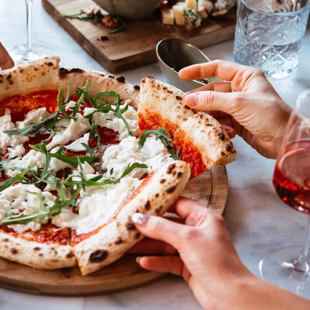 Foto mehrere eingeladene Kollegen teilen sich eine Pizza