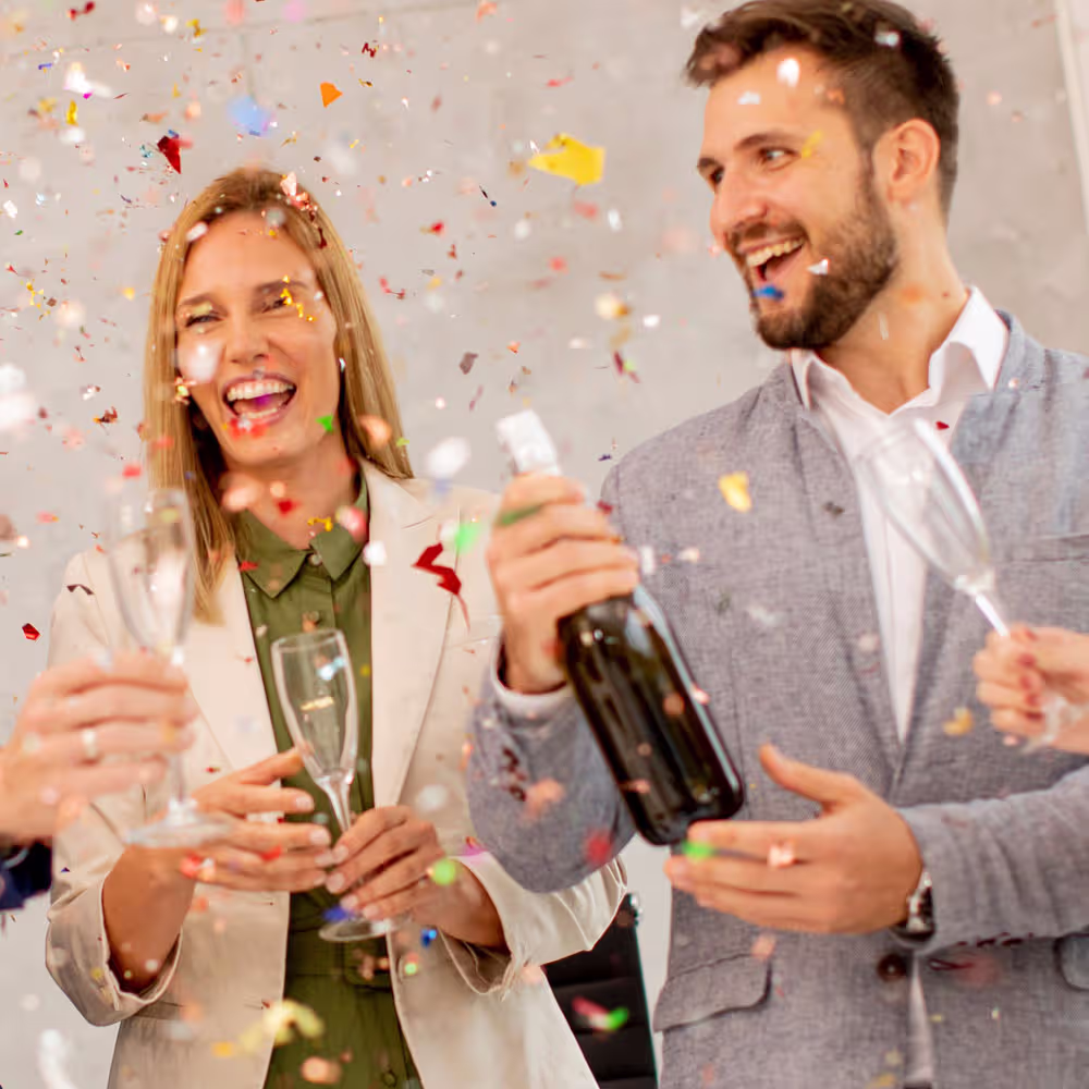 Foto feierndes Paar beim &Ouml;ffnen einer Sektflasche zum Jubil&auml;um