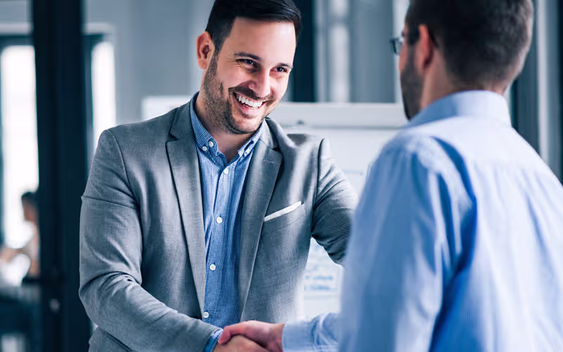 Foto zwei Mitarbeiter Kollegen die sich die H&auml;nde reichen zum Gratulieren