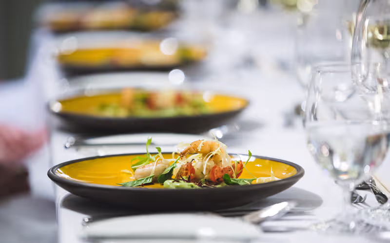 Foto gedeckter Hochzeitstisch mit orangenen Tellern mit Vorspeise zur Hochzeit